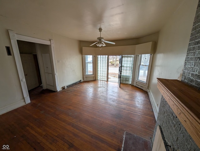 unfurnished living room featuring ceiling fan, dark hardwood / wood-style floors, and a baseboard heating unit