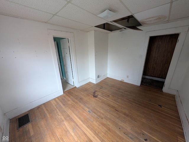 spare room featuring a paneled ceiling and hardwood / wood-style flooring