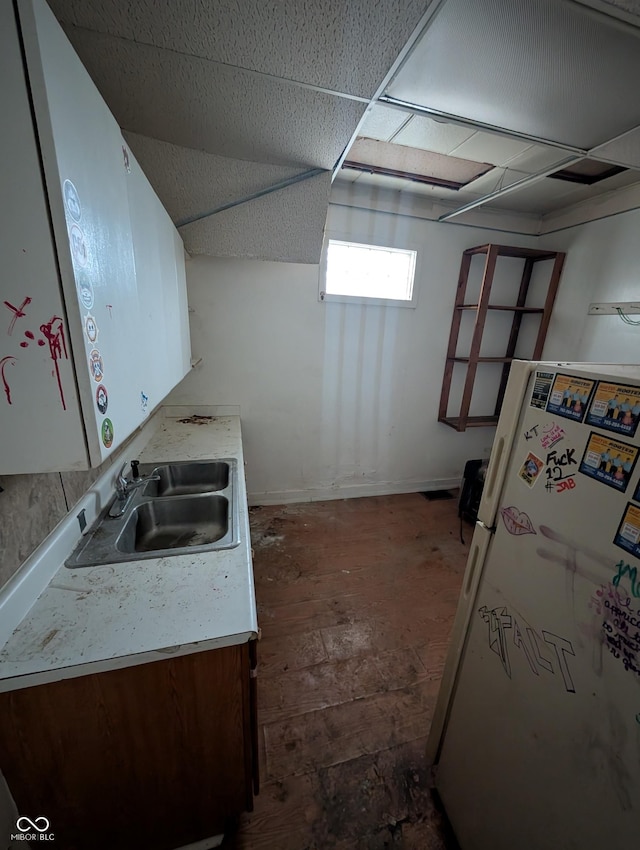 kitchen with white cabinets, white fridge, and sink