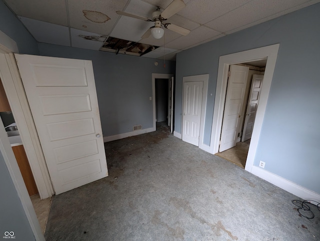 unfurnished bedroom with a drop ceiling and ceiling fan