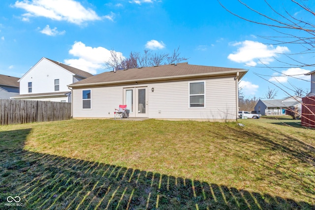 rear view of property featuring a lawn