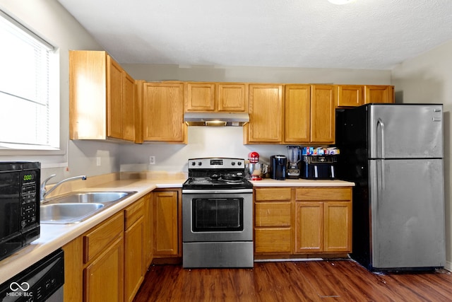 kitchen with a textured ceiling, sink, stainless steel appliances, and dark hardwood / wood-style floors