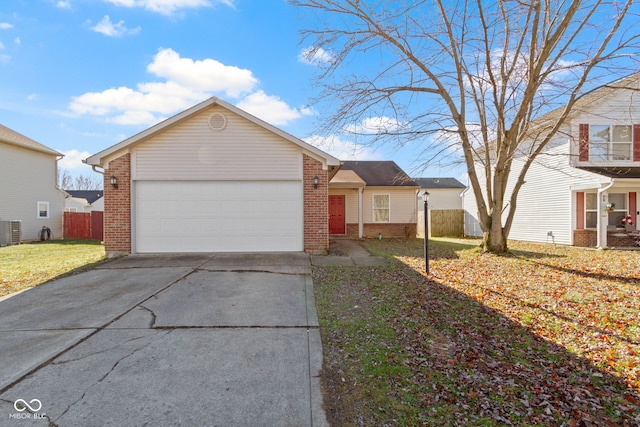 view of front of home with central AC, a garage, and a front lawn