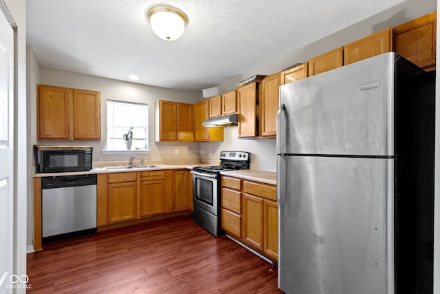 kitchen featuring a textured ceiling, dark hardwood / wood-style floors, sink, and stainless steel appliances