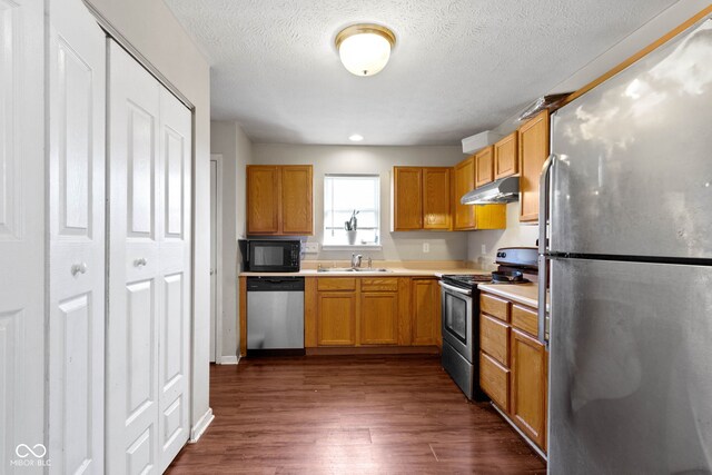 kitchen with black appliances, dark hardwood / wood-style floors, and a textured ceiling