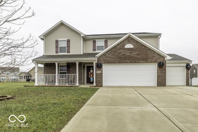 view of property featuring a porch, a garage, and a front lawn