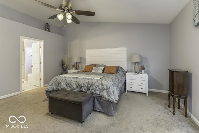 bedroom featuring ceiling fan, light colored carpet, ensuite bathroom, and vaulted ceiling