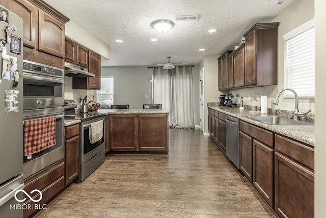 kitchen featuring dark wood-type flooring, sink, stainless steel appliances, and plenty of natural light