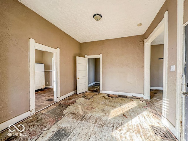 unfurnished bedroom featuring white fridge