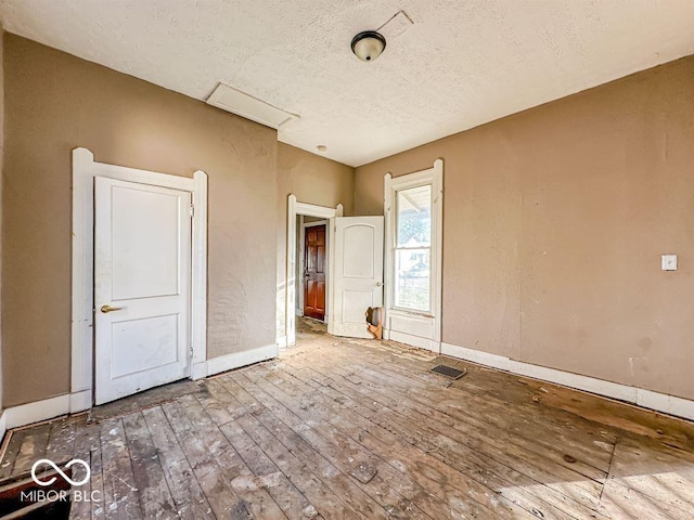 unfurnished bedroom with hardwood / wood-style floors and a textured ceiling