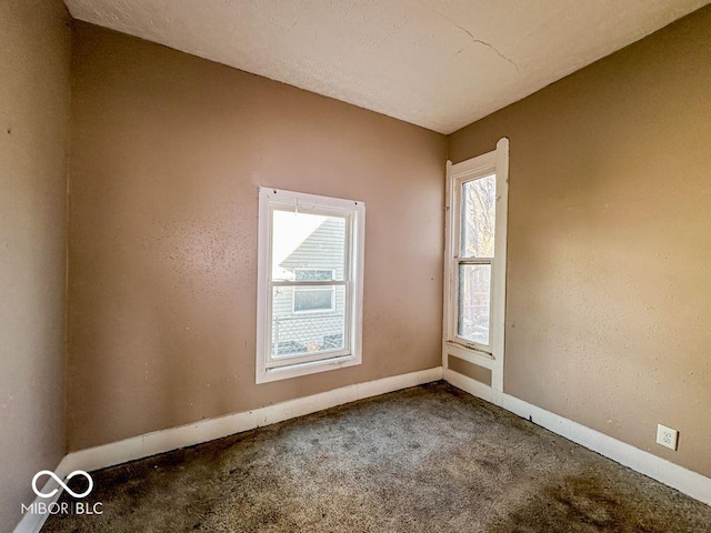 unfurnished room featuring carpet flooring and a textured ceiling