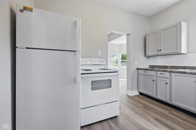 2218 N Arsenal Ave, Indianapolis, IN 46218 - kitchen with white appliances, wood finished floors, tasteful backsplash, and dark countertops