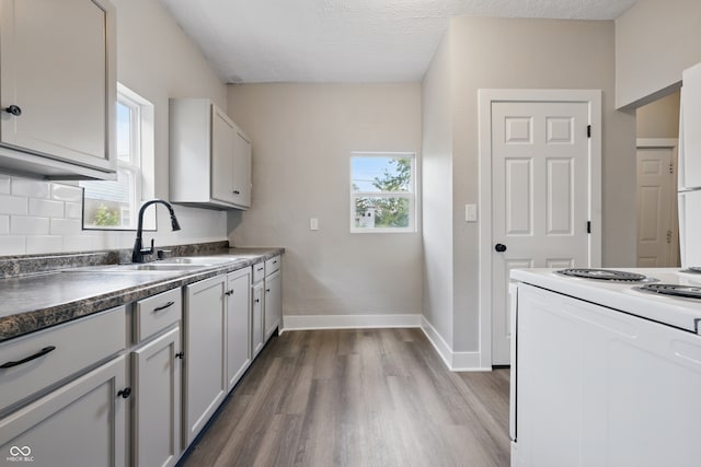 2218 N Arsenal Ave, Indianapolis, IN 46218 - kitchen featuring white range with electric cooktop, dark wood-style flooring, plenty of natural light, and dark countertops