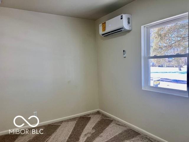 spare room with a wall mounted AC, a wealth of natural light, and carpet flooring