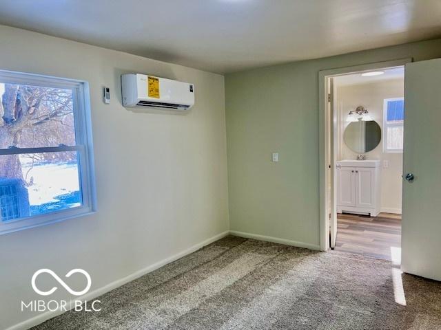 spare room featuring carpet floors and a wall unit AC