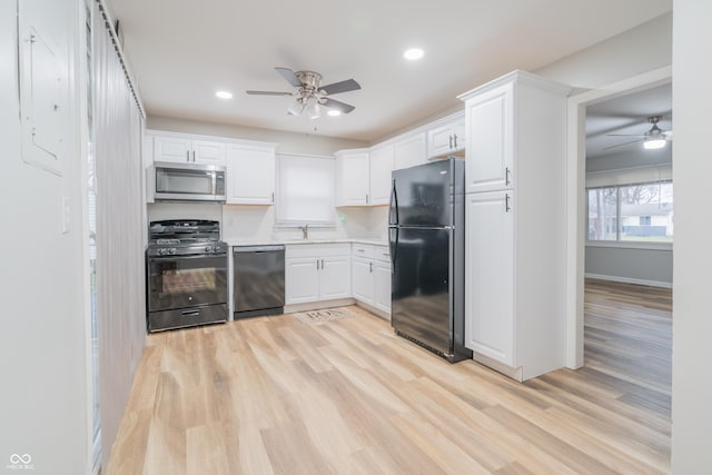 kitchen featuring white cabinetry, light hardwood / wood-style flooring, and black appliances