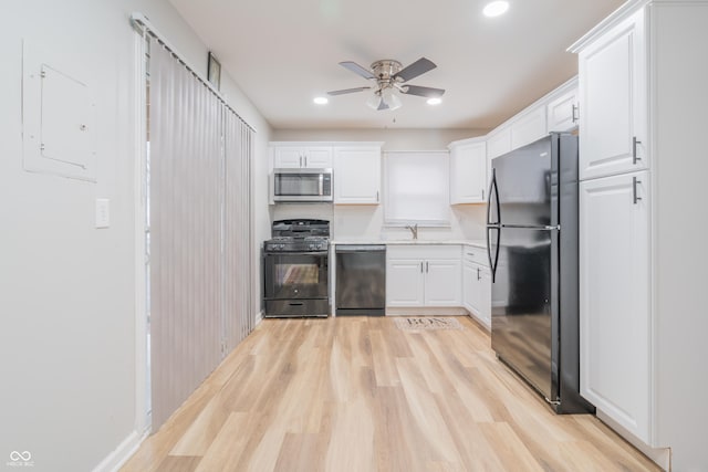 kitchen featuring white cabinets, black appliances, and light wood-type flooring