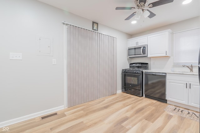 kitchen featuring light wood-type flooring, white cabinetry, ceiling fan, and black appliances