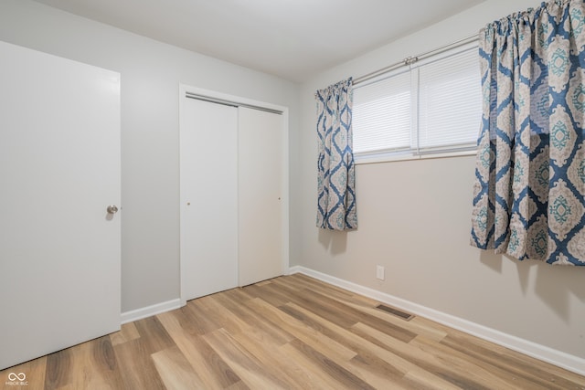 unfurnished bedroom with a closet and light hardwood / wood-style flooring