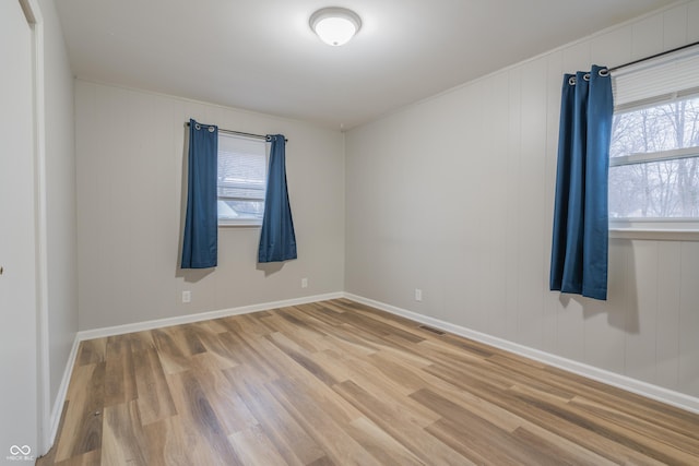 spare room with hardwood / wood-style flooring and a healthy amount of sunlight