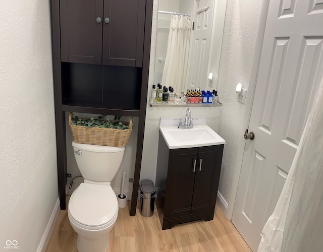 bathroom featuring wood-type flooring, vanity, and toilet