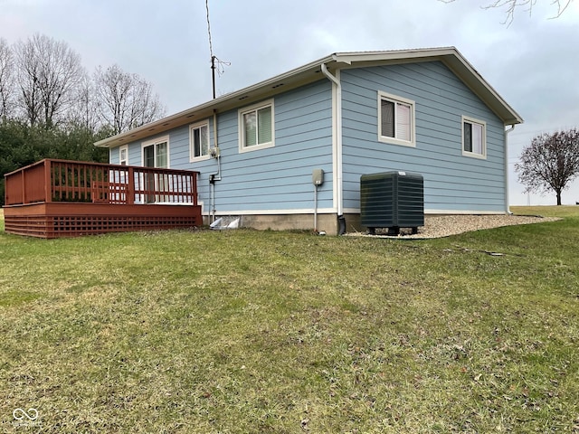 back of property with a deck, central air condition unit, and a yard