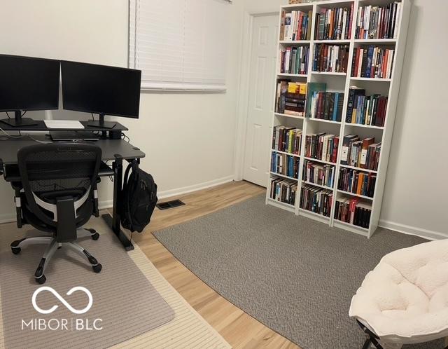 office featuring visible vents, baseboards, and wood finished floors