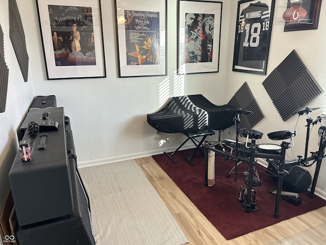 exercise area with baseboards and wood finished floors