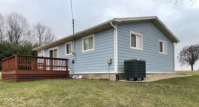 back of house featuring a deck, central AC unit, and a lawn