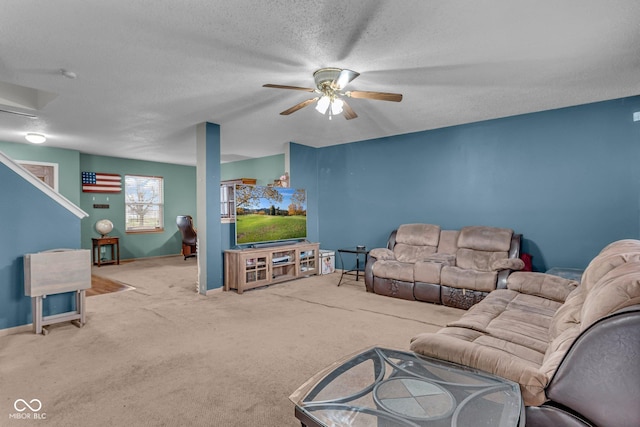 carpeted living room featuring a textured ceiling and ceiling fan