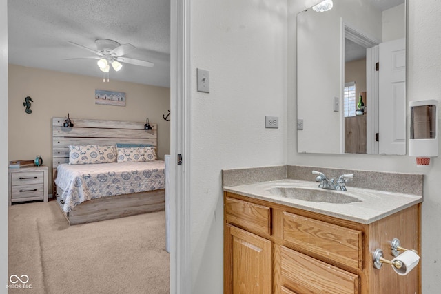 bathroom featuring ceiling fan, vanity, and a textured ceiling