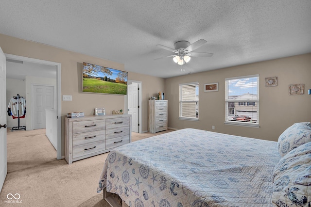 carpeted bedroom featuring a textured ceiling and ceiling fan