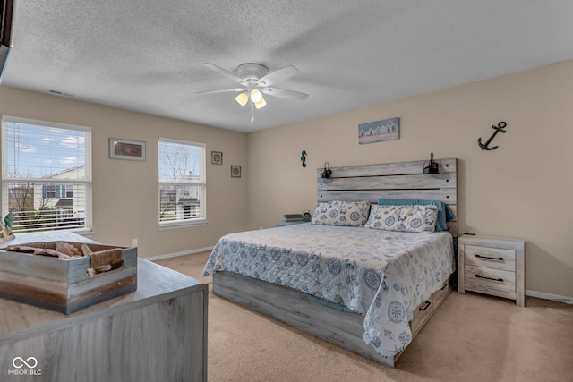 carpeted bedroom featuring a textured ceiling and ceiling fan