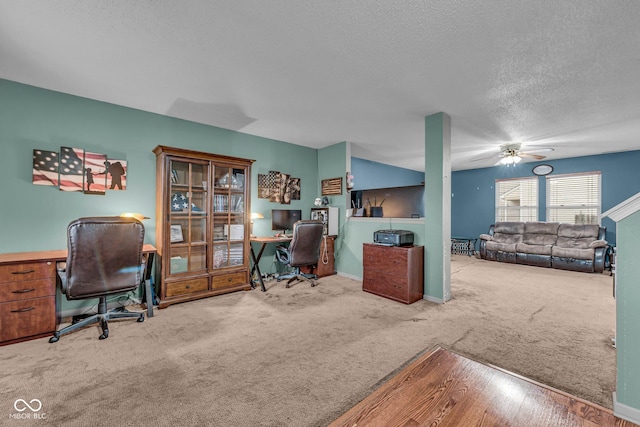 carpeted home office featuring ceiling fan and a textured ceiling