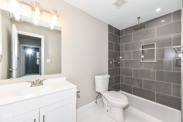 bathroom featuring tile patterned floors, vanity, toilet, and tiled shower