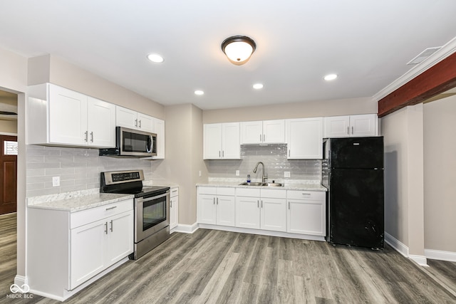 kitchen featuring light stone counters, stainless steel appliances, sink, white cabinets, and light hardwood / wood-style floors