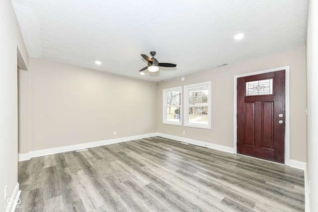 entryway with ceiling fan, light hardwood / wood-style floors, and a textured ceiling