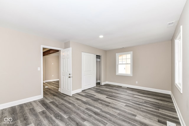 unfurnished bedroom with dark hardwood / wood-style floors and a closet