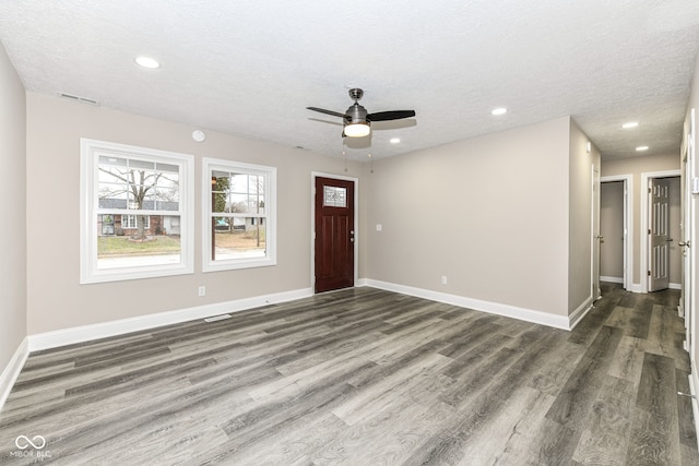 entryway with ceiling fan, dark hardwood / wood-style floors, and a textured ceiling