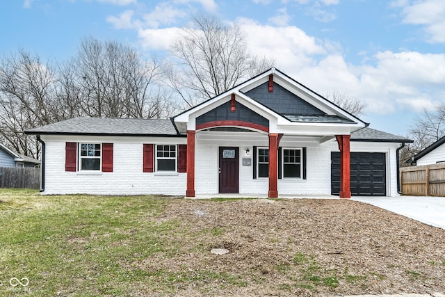 view of front of property featuring covered porch, a front yard, and a garage