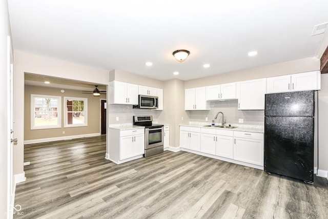 kitchen with white cabinets, decorative backsplash, stainless steel appliances, and sink