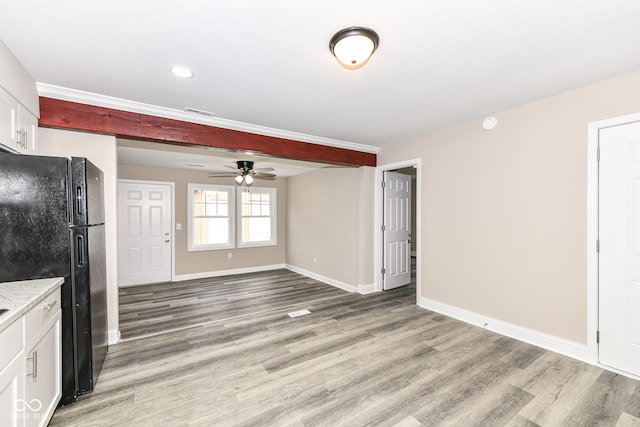 kitchen featuring ceiling fan, black refrigerator, white cabinets, and light hardwood / wood-style flooring