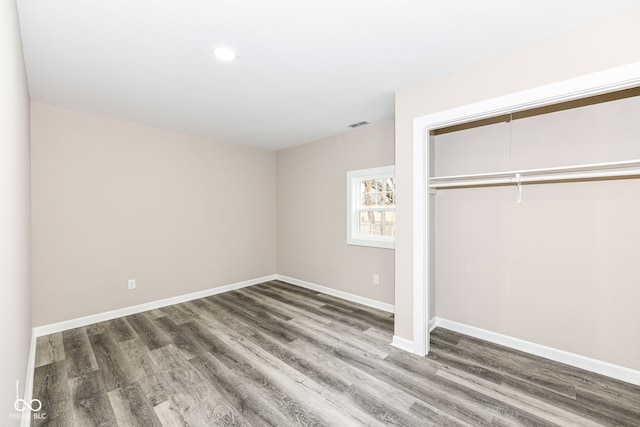 unfurnished bedroom featuring dark hardwood / wood-style floors and a closet