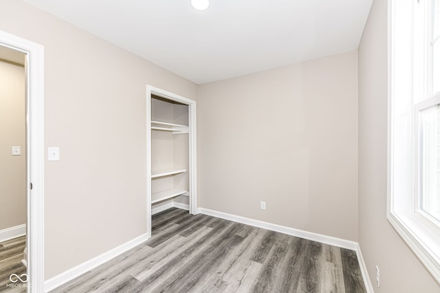 unfurnished bedroom with hardwood / wood-style flooring and a closet