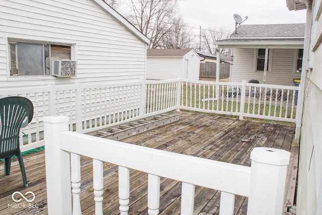 wooden deck featuring cooling unit and a storage shed