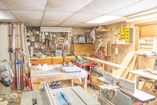 miscellaneous room with a workshop area and a drop ceiling