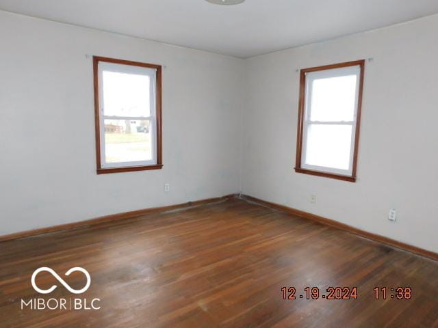 unfurnished room featuring dark hardwood / wood-style floors and a healthy amount of sunlight