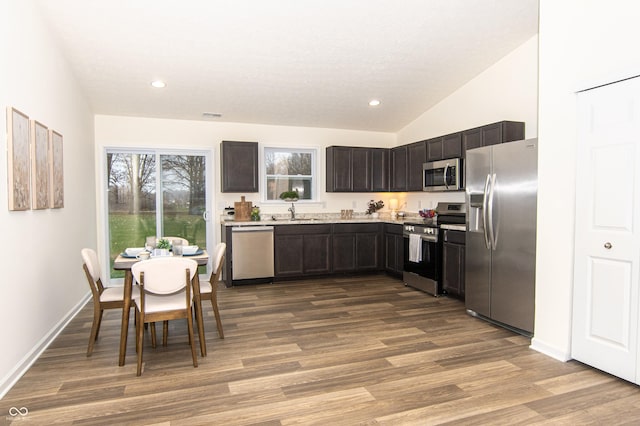 kitchen with dark brown cabinetry, sink, stainless steel appliances, light hardwood / wood-style flooring, and lofted ceiling