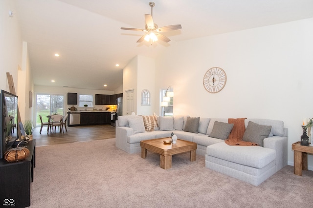 carpeted living room with high vaulted ceiling and ceiling fan