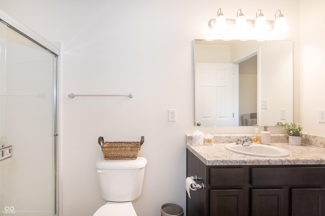 bathroom with vanity, toilet, and a shower with shower door